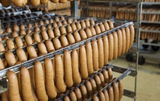 Rows of sausages hanging in a factory