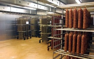 Sausages hanging in a meat drying facility.