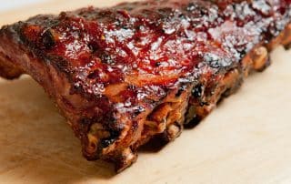 Barbecue ribs with sauce on wooden board